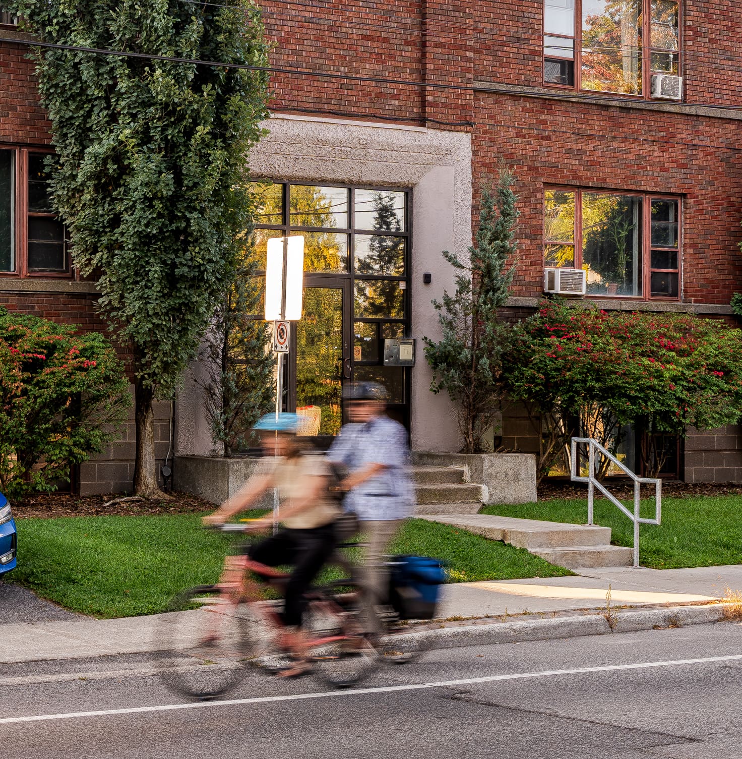 People riding bikes in front of building