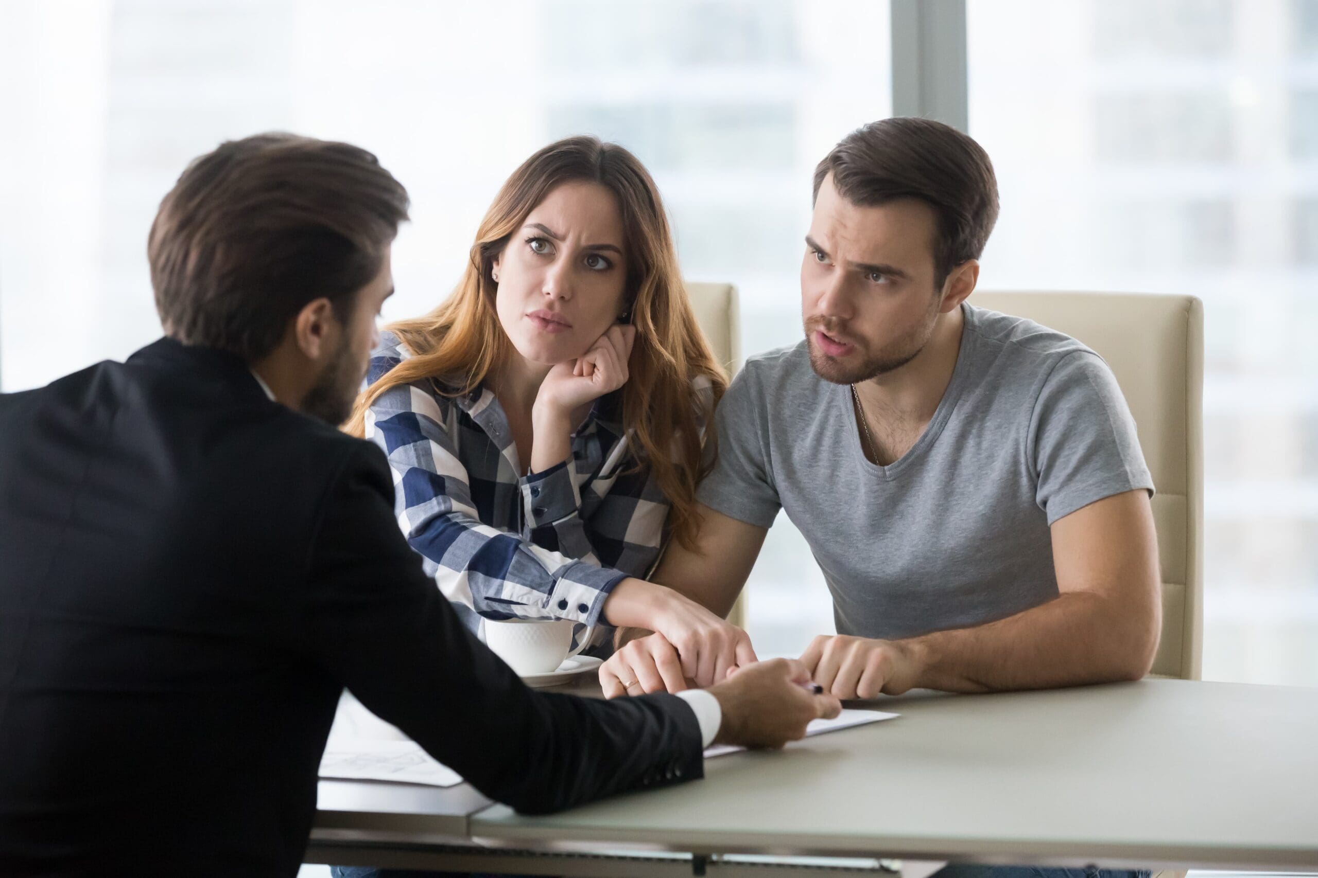 angry and dissatisfied young couple arguing with a landlord